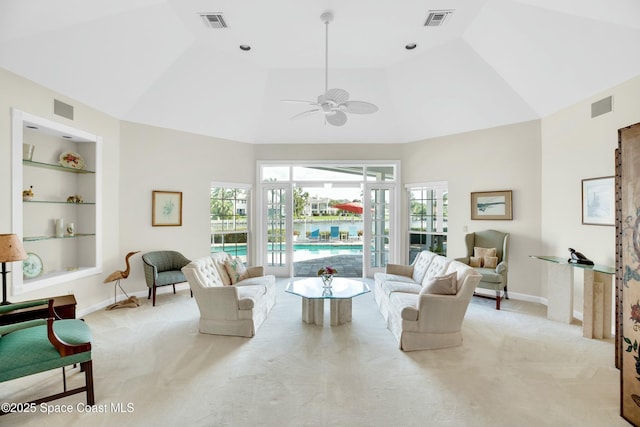 living room with a healthy amount of sunlight, light carpet, and built in features