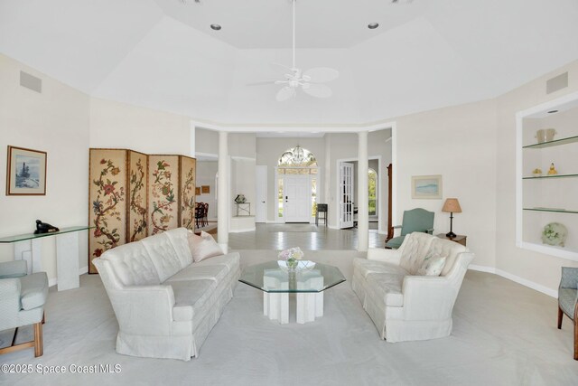 living room with ornate columns, ceiling fan, and built in shelves