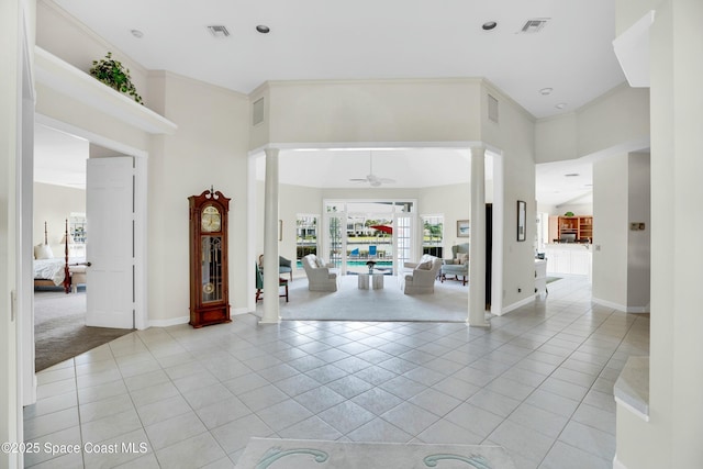 tiled foyer entrance featuring ornate columns, crown molding, and ceiling fan