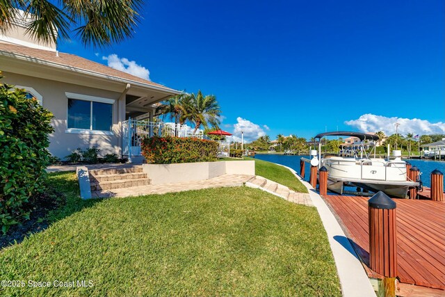 view of yard with a boat dock and a water view