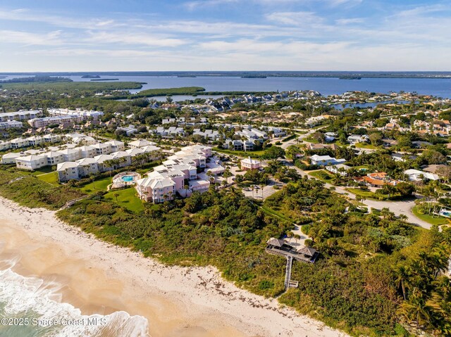 birds eye view of property with a water view and a beach view