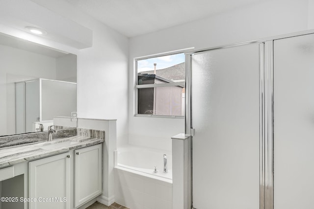 full bath with a stall shower, vanity, and a bath