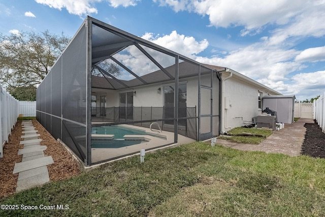 rear view of house featuring a fenced in pool, a patio, stucco siding, glass enclosure, and a fenced backyard