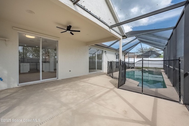 view of swimming pool featuring glass enclosure, a pool with connected hot tub, a patio area, and ceiling fan