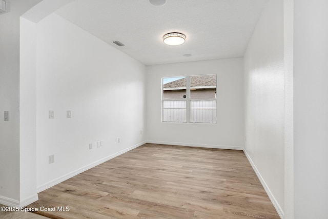 unfurnished room featuring light wood-style floors, baseboards, and visible vents