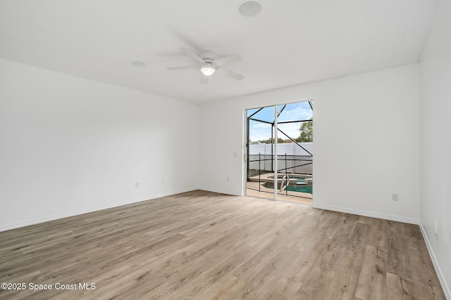 unfurnished room featuring a ceiling fan, baseboards, and wood finished floors