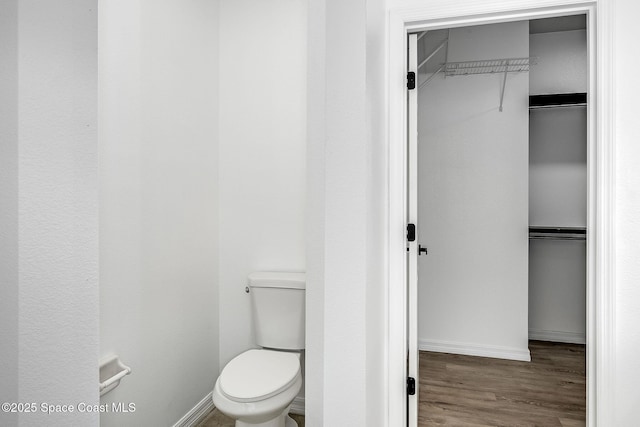 bathroom featuring baseboards, toilet, and wood finished floors