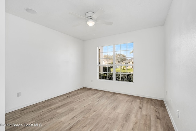 unfurnished room featuring a ceiling fan, baseboards, and wood finished floors