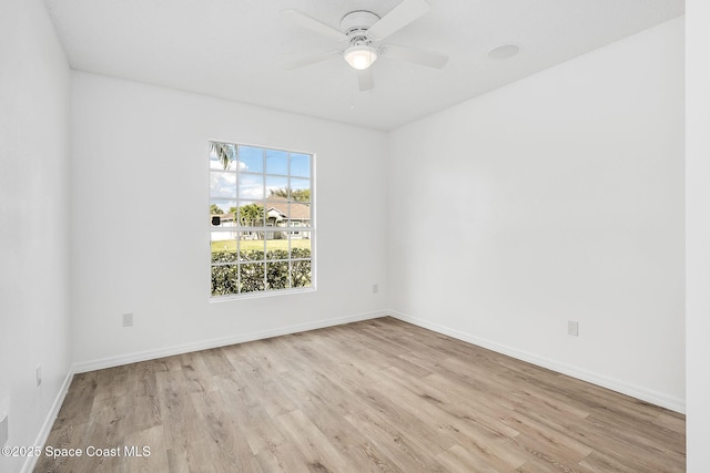 empty room featuring ceiling fan, baseboards, and wood finished floors