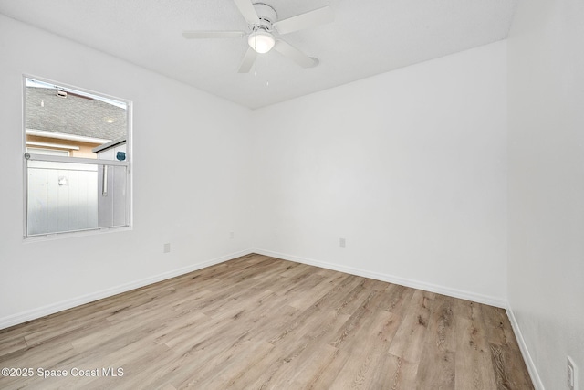 empty room with a ceiling fan, baseboards, and wood finished floors