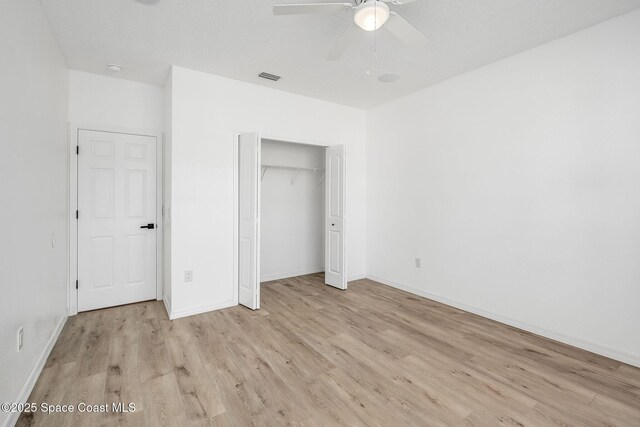 unfurnished bedroom with ceiling fan, a closet, wood finished floors, and baseboards