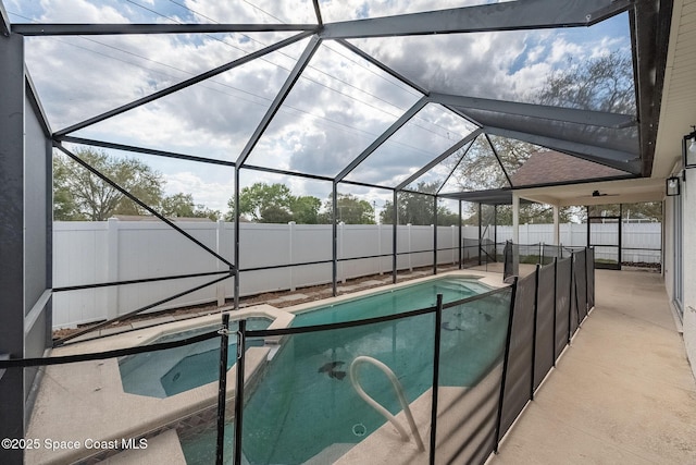 view of pool featuring a patio area, a fenced backyard, a pool with connected hot tub, and a lanai