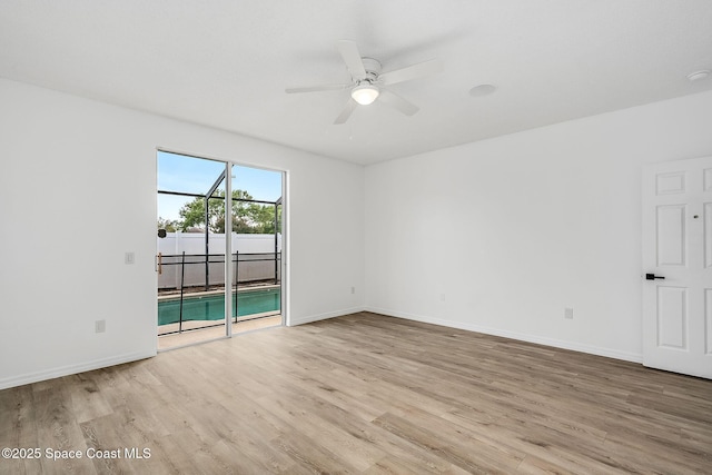 empty room featuring baseboards, ceiling fan, and light wood-style floors