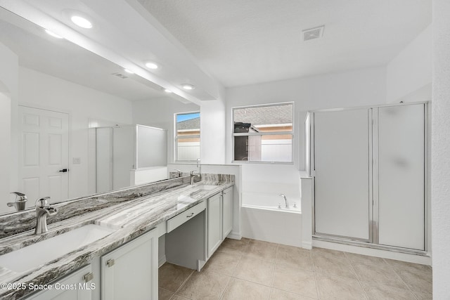 bathroom with double vanity, visible vents, a bath, a shower stall, and a sink