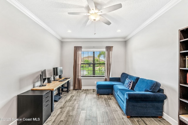 office space featuring a textured ceiling, a ceiling fan, light wood-style flooring, and crown molding