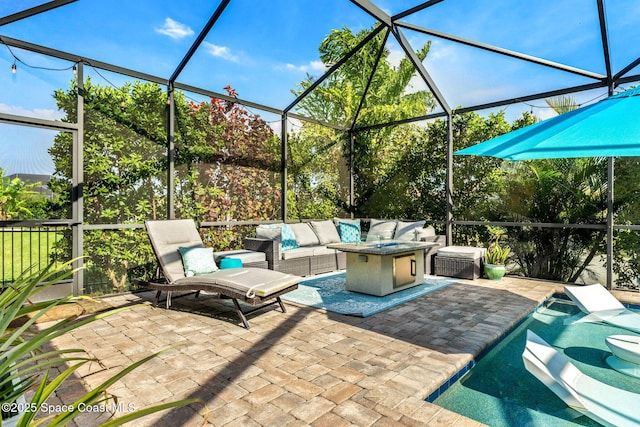 view of patio featuring glass enclosure and an outdoor living space with a fire pit