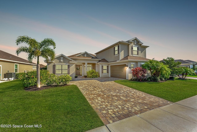 8187 Crimson Dr, Melbourne, FL 32940 - view of front facade with decorative driveway, stucco siding, a garage, and a front yard