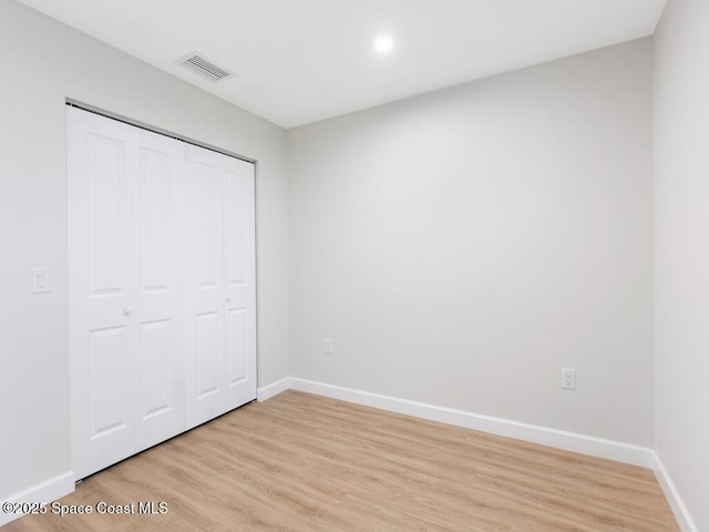 unfurnished bedroom with light hardwood / wood-style floors and a closet