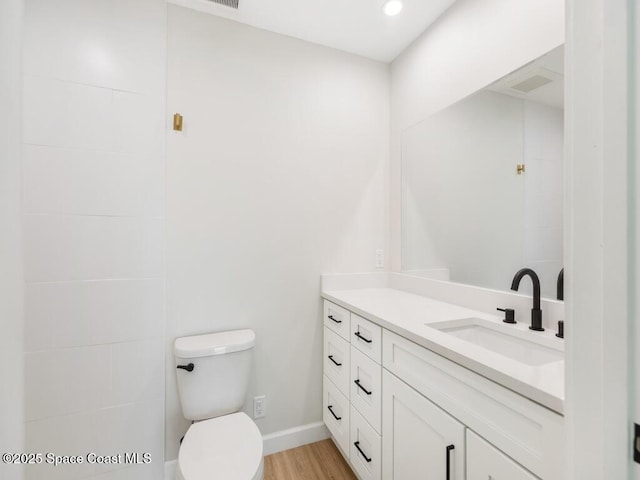 bathroom featuring vanity, hardwood / wood-style floors, and toilet