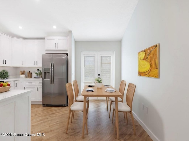 kitchen featuring white cabinetry, stainless steel fridge, light hardwood / wood-style floors, and french doors