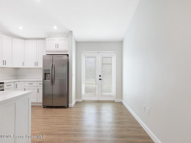 kitchen featuring white cabinetry, stainless steel fridge, and light hardwood / wood-style flooring