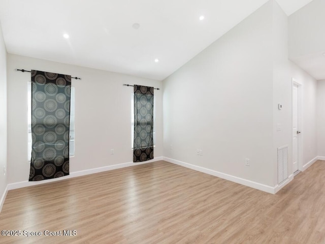 unfurnished room with light hardwood / wood-style flooring and vaulted ceiling