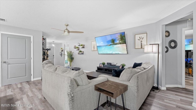 living room featuring ceiling fan and light wood-type flooring