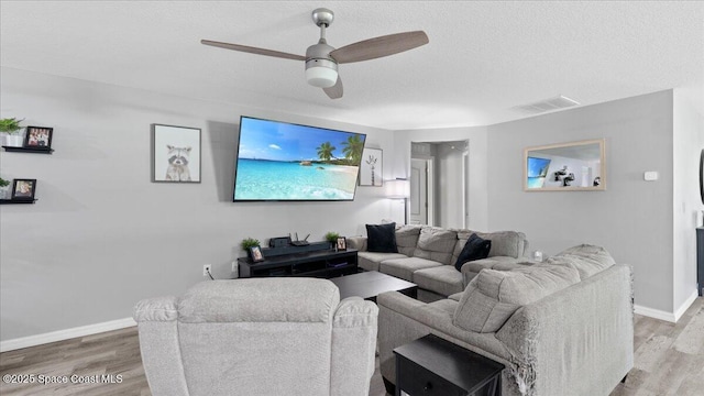 living room with ceiling fan, hardwood / wood-style floors, and a textured ceiling