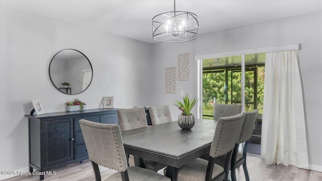 dining room with light hardwood / wood-style flooring and a chandelier