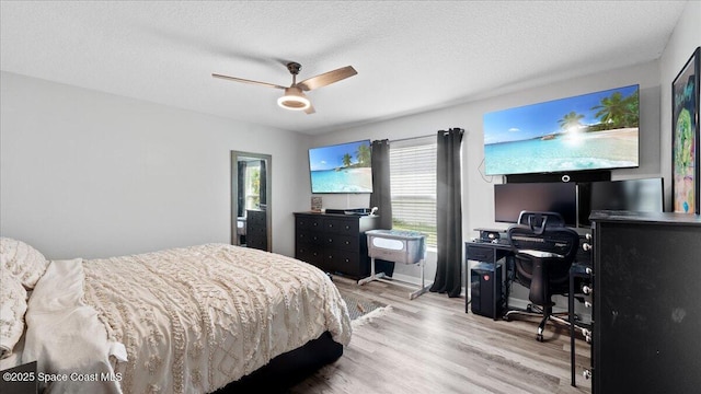 bedroom featuring ceiling fan, a textured ceiling, and light hardwood / wood-style flooring