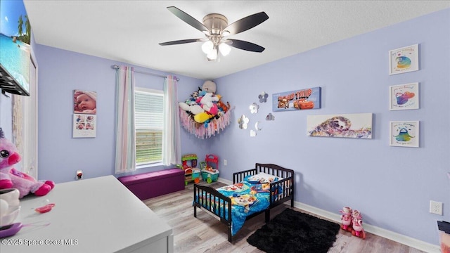 bedroom with ceiling fan, a textured ceiling, and light wood-type flooring