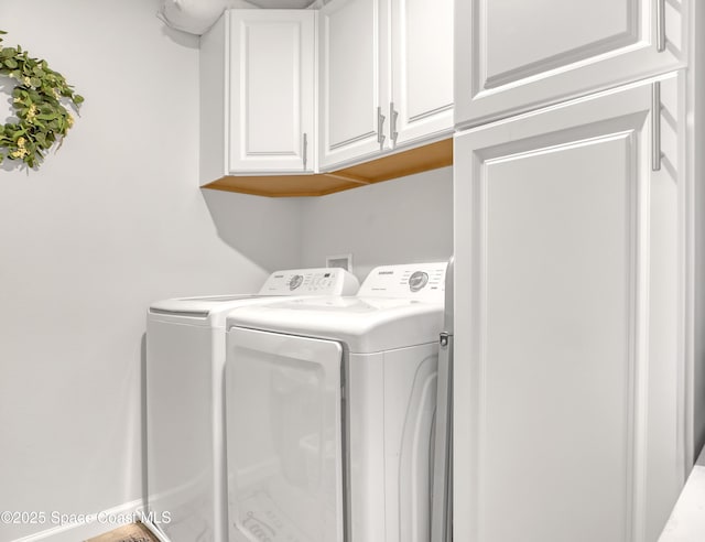 clothes washing area featuring washing machine and dryer and cabinets