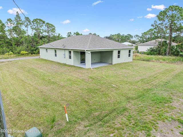 back of house with a patio area, a lawn, and stucco siding