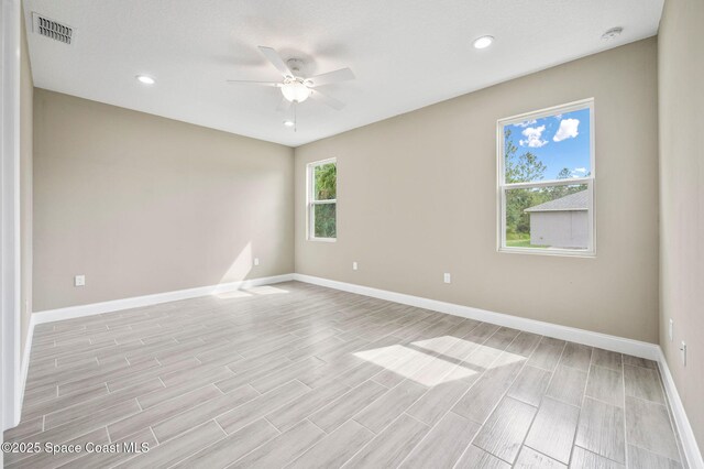 unfurnished room with wood finish floors, recessed lighting, visible vents, ceiling fan, and baseboards