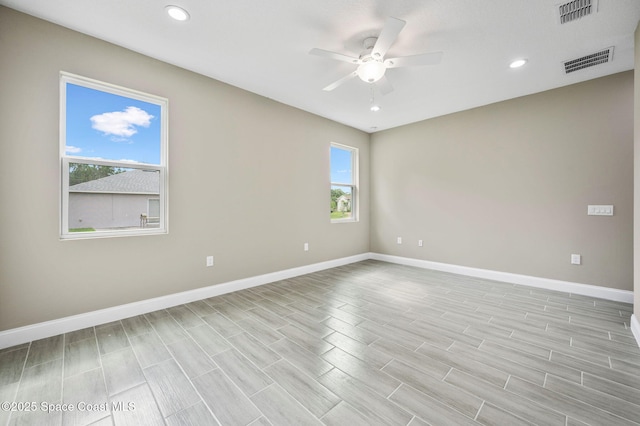 unfurnished room featuring ceiling fan, visible vents, and baseboards