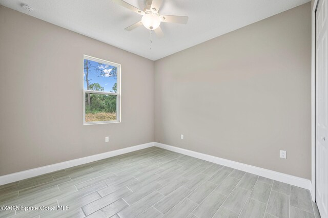 unfurnished room with ceiling fan, light wood-type flooring, and baseboards