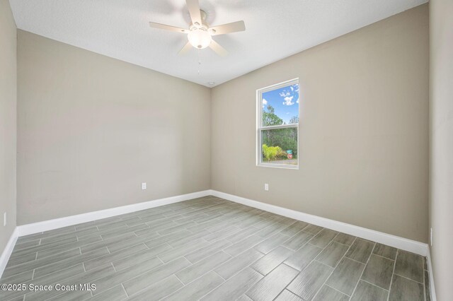 empty room with ceiling fan, light wood-style flooring, and baseboards