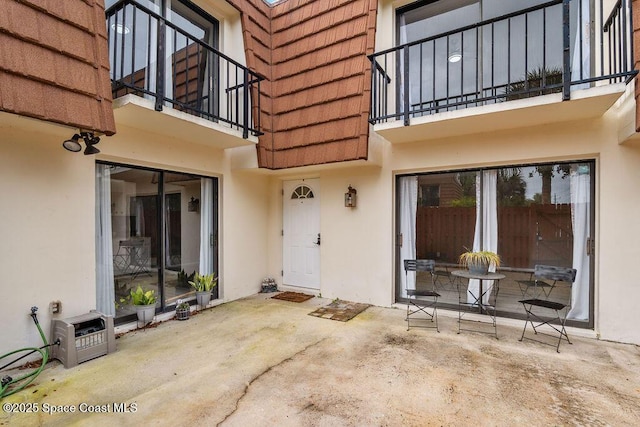 doorway to property featuring heating unit and a patio