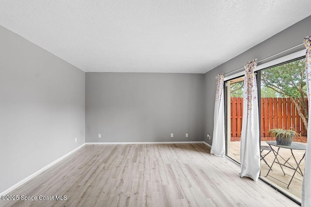 unfurnished room featuring a textured ceiling and light wood-type flooring