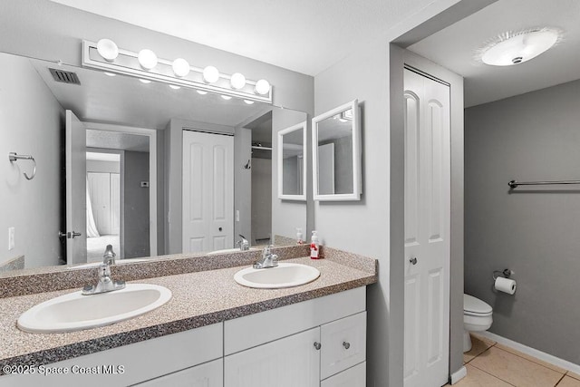 bathroom featuring vanity, tile patterned floors, and toilet