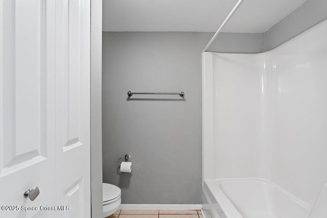 bathroom featuring shower / bathtub combination, toilet, and tile patterned flooring