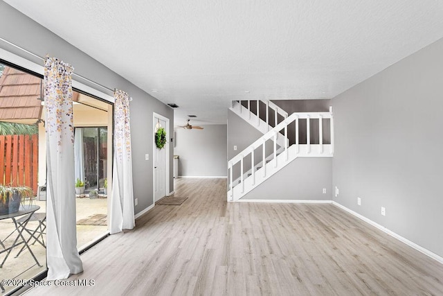 interior space featuring ceiling fan, a textured ceiling, and light hardwood / wood-style flooring