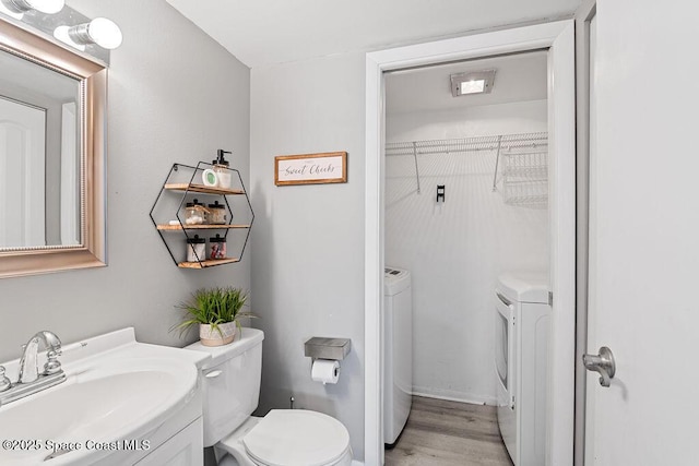 bathroom featuring vanity, hardwood / wood-style floors, and washing machine and clothes dryer