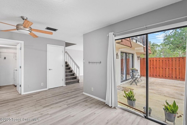 empty room featuring ceiling fan, light hardwood / wood-style floors, and a textured ceiling