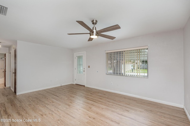 spare room with ceiling fan, light wood-type flooring, visible vents, and baseboards