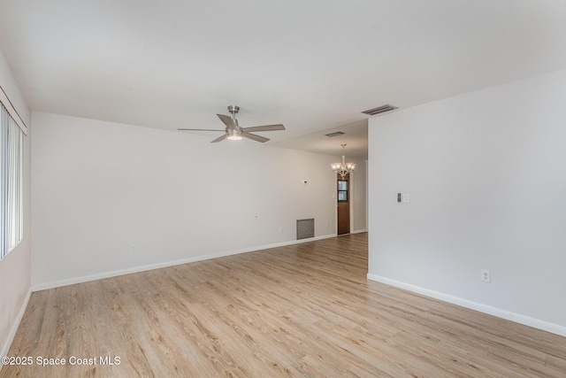 unfurnished room with ceiling fan with notable chandelier, light wood finished floors, visible vents, and baseboards