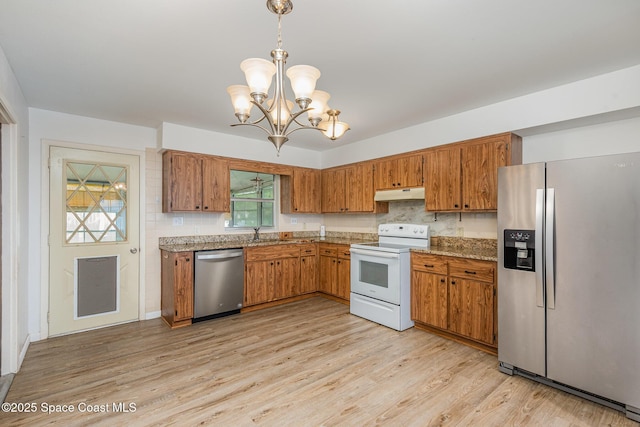 kitchen with stainless steel appliances, decorative light fixtures, under cabinet range hood, and light wood finished floors