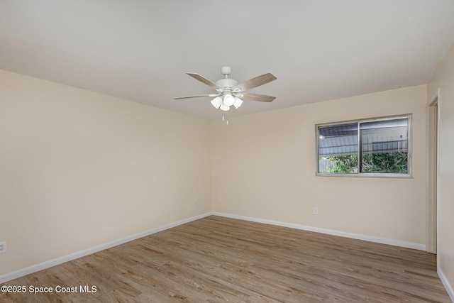 spare room with ceiling fan, baseboards, and wood finished floors