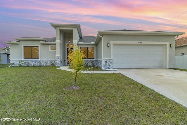 view of front of home featuring a garage and a yard