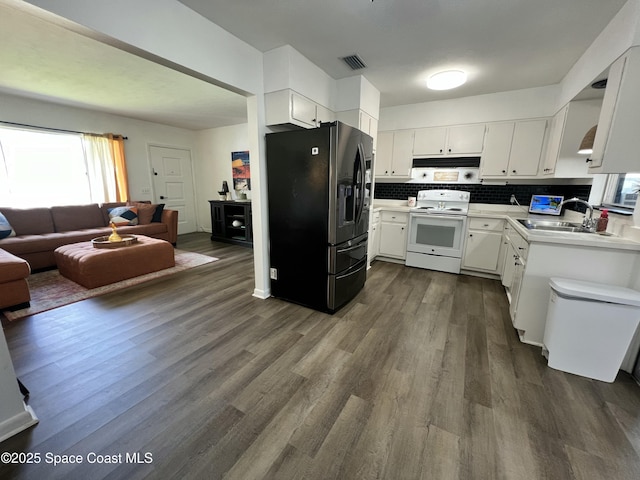 kitchen with white cabinetry, sink, stainless steel fridge, dark wood-type flooring, and electric stove